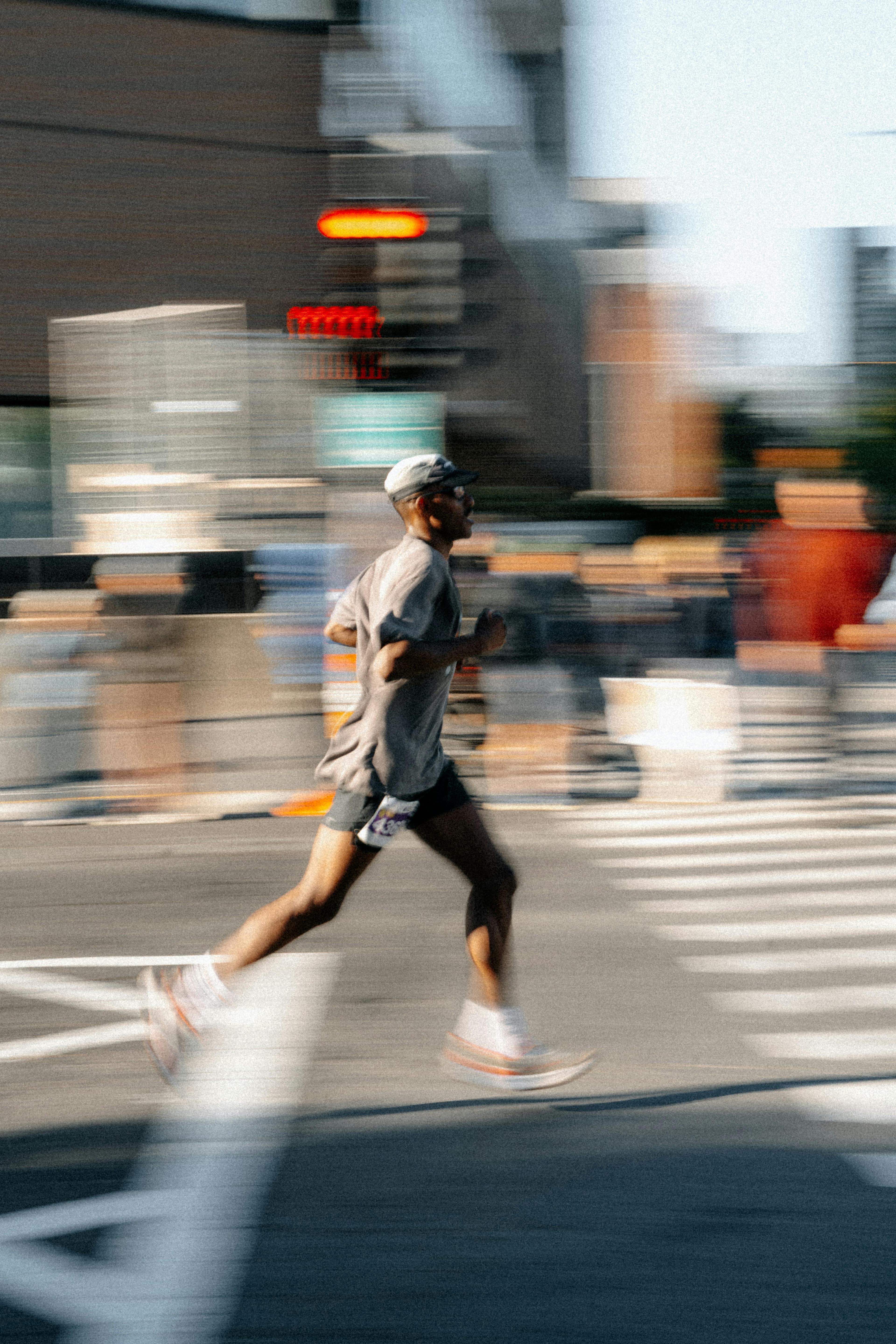 A runner mid-stride through a city intersection